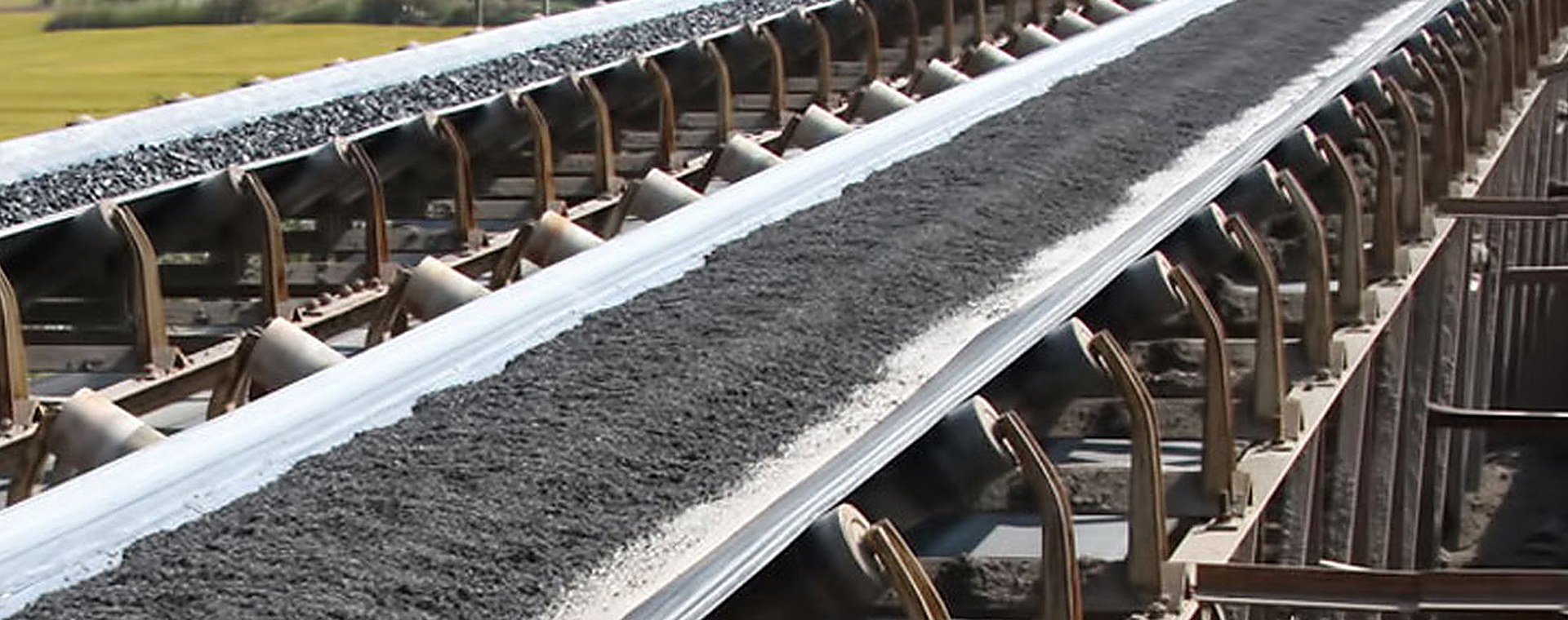 Rebell belt conveyor carrying bulk material through a plant